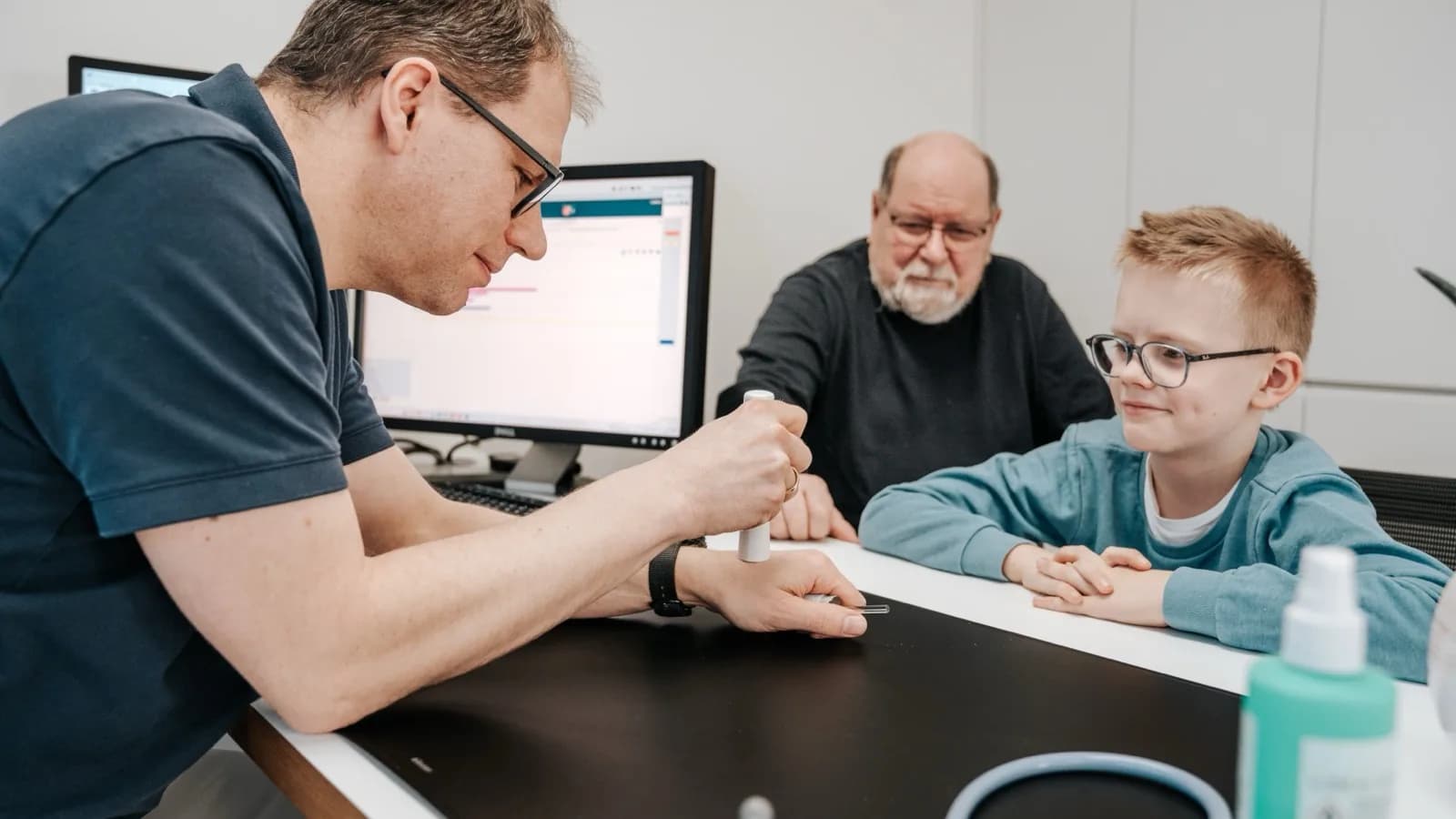 Arzt erklärt einem Jungen und einem älteren Patienten eine Untersuchung